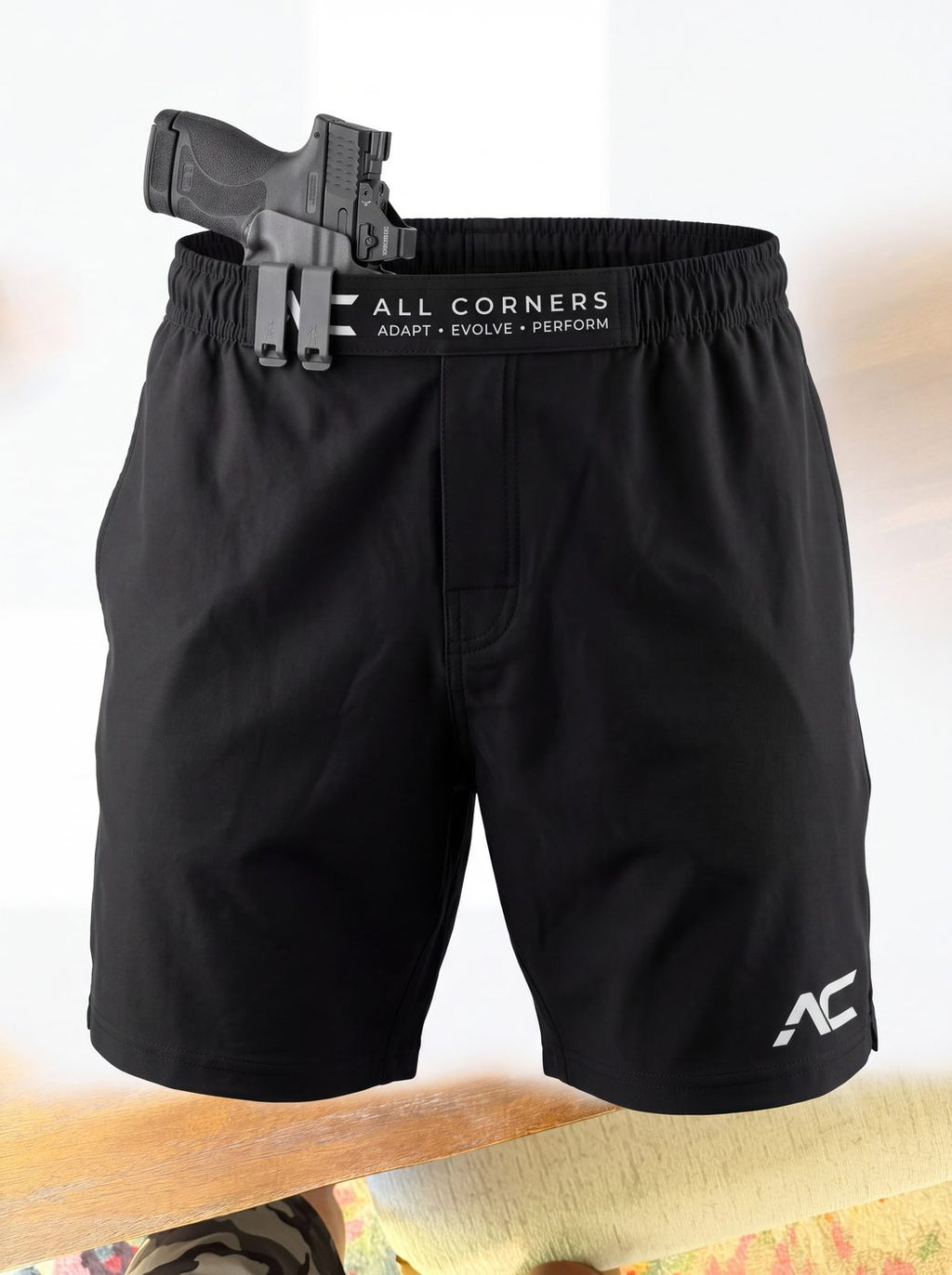 ALL CORNERS black shorts with a holstered firearm clipped to the patent-pending retention waistband