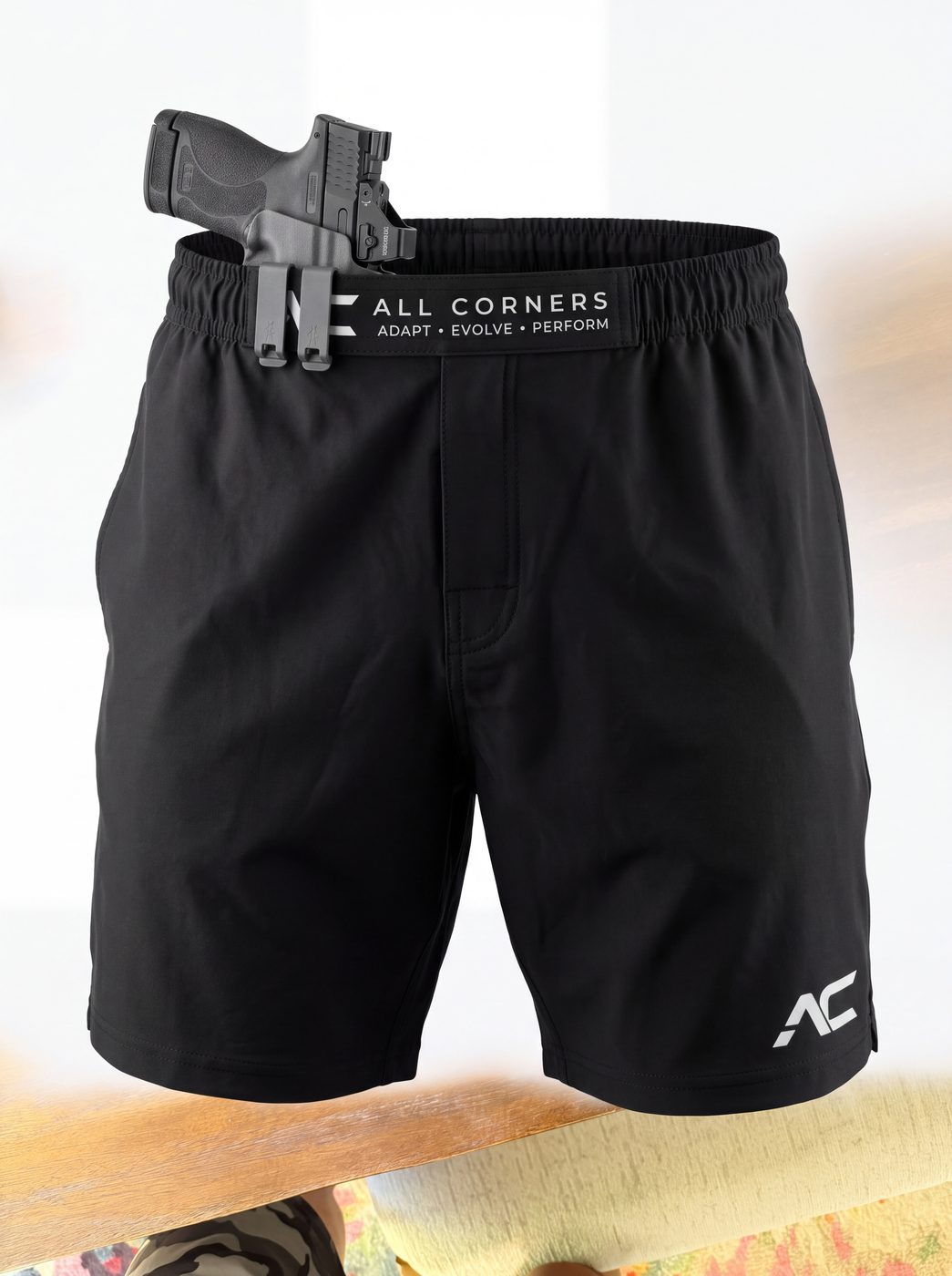 ALL CORNERS black shorts with a holstered firearm clipped to the patent-pending retention waistband
