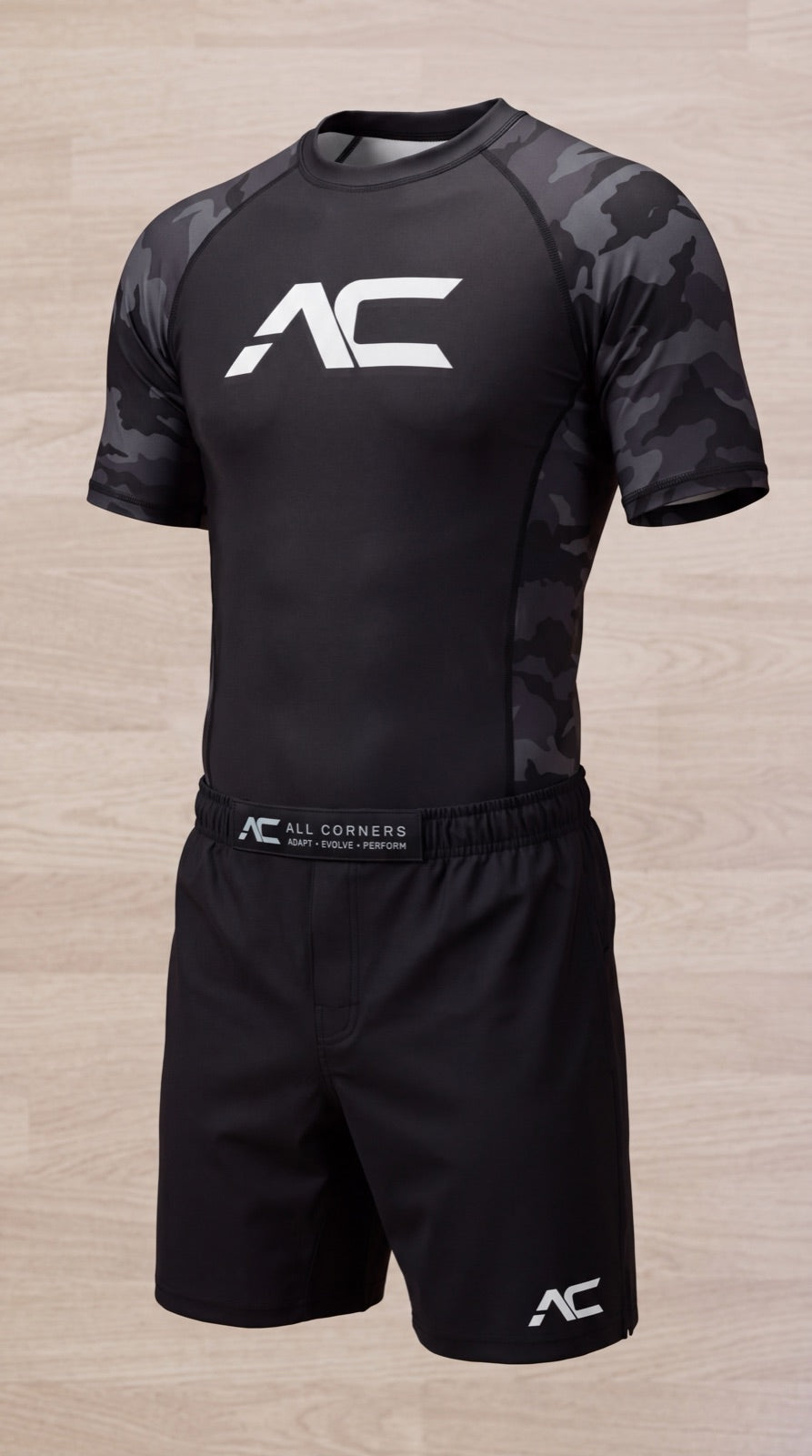 ALL CORNERS rashguard and shorts together, waistband reading ADAPT EVOLVE PERFORM