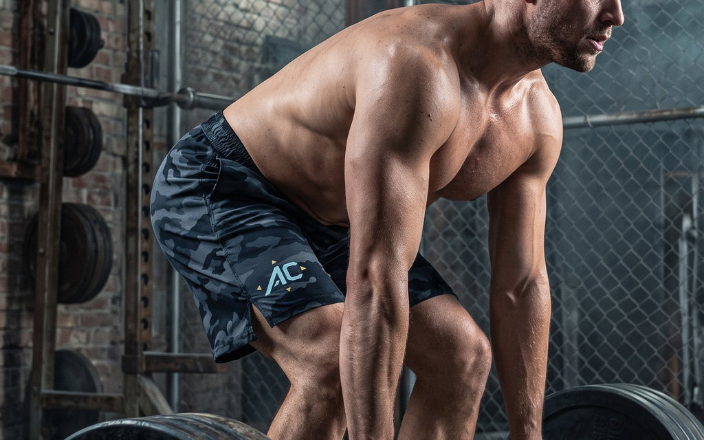 Athlete setting up over a loaded barbell in ALL CORNERS camo shorts