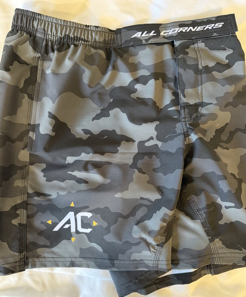 Flat lay of the ALL CORNERS grayscale camo shorts showing branded waistband, convertible pocket and AC logo